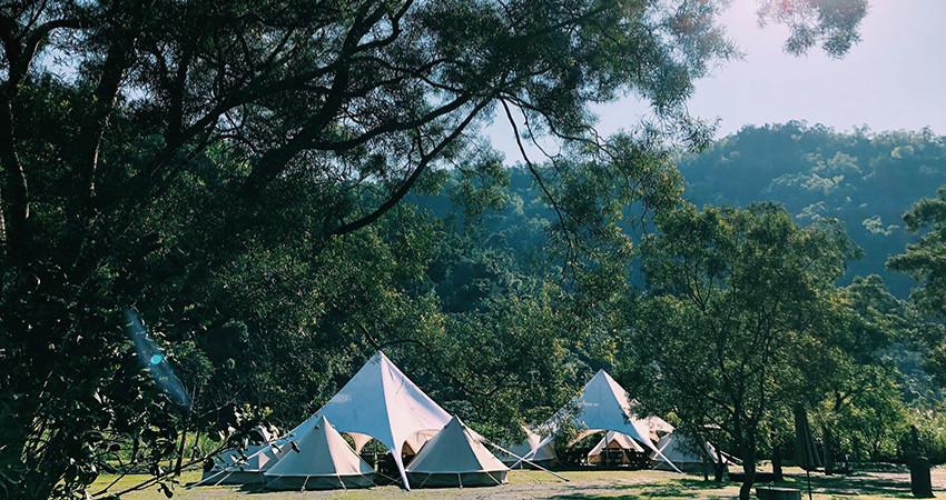「東風綠活」打造在柚子果園裡的無痕露營，所有設備都幫你準備好，一頂頂白色帳篷矗立， 像極了山林裡的精靈部落